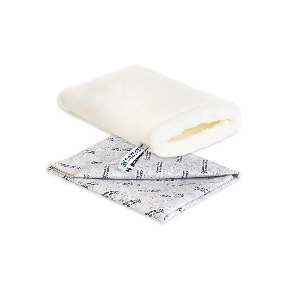 uni-szary A folded cream-colored fleece pouch sits above a rectangular silver bag labeled "Zestaw Uniwersalny Różowy," both placed on a white background.